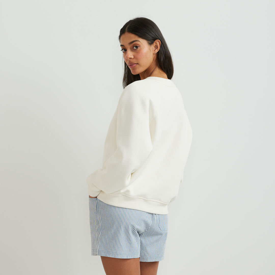 Dame iført ensfarvet sweatshirt med rund hals, lange ærmer og ribkanter