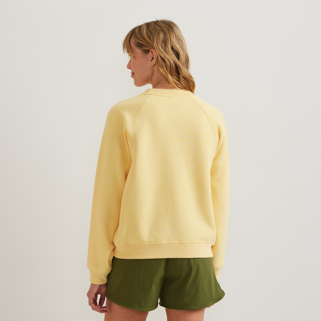 Dame iført ensfarvet sweatshirt med rund hals, lange ærmer og ribkanter