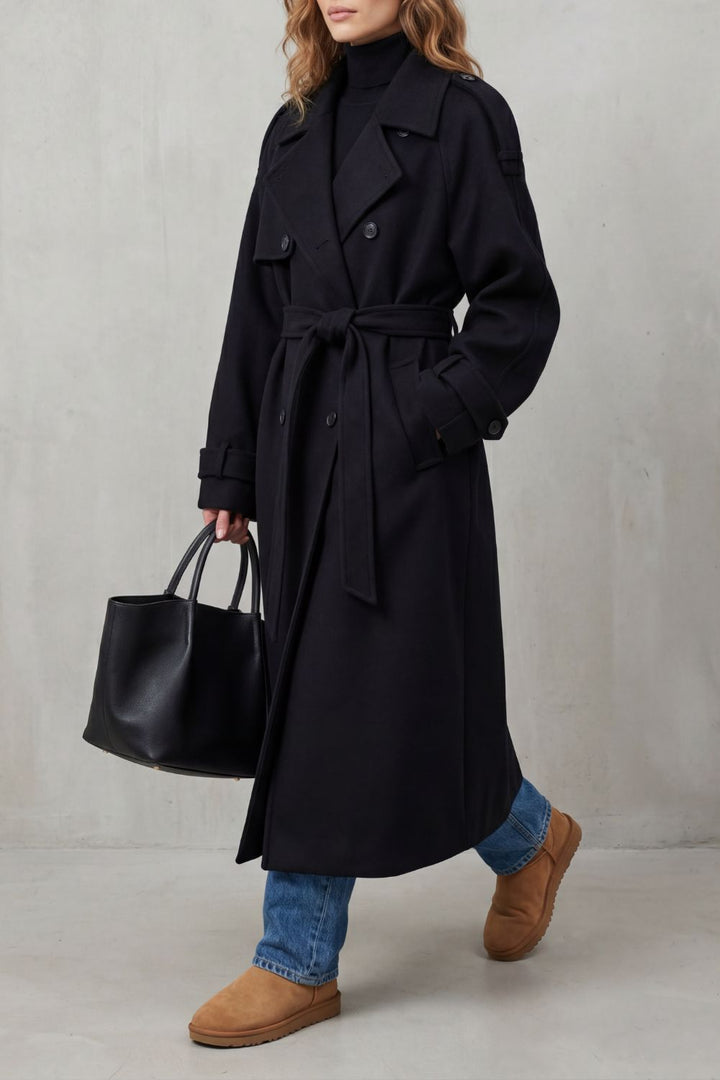 Sort dame-trenchcoat med brede revers, knapper og bindebælte