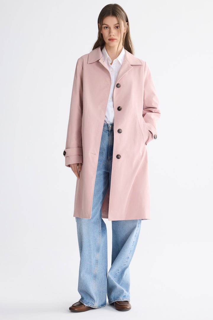 Dame i enradet trenchcoat med klassisk krave, knaplukning og lange ærmer
