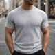 Herre iført ensfarvet strikket T-shirt med rund hals og korte ærmer