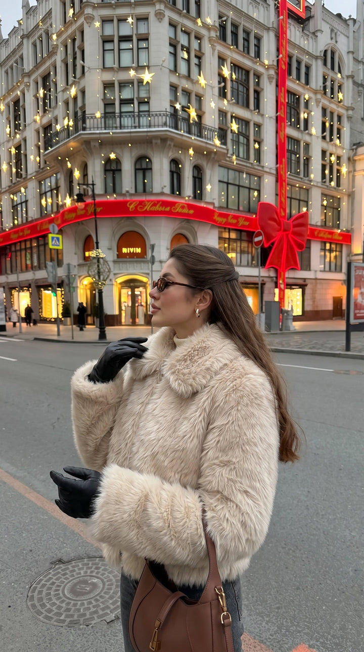 Dame i beige jakke i imiteret pels med stor krave