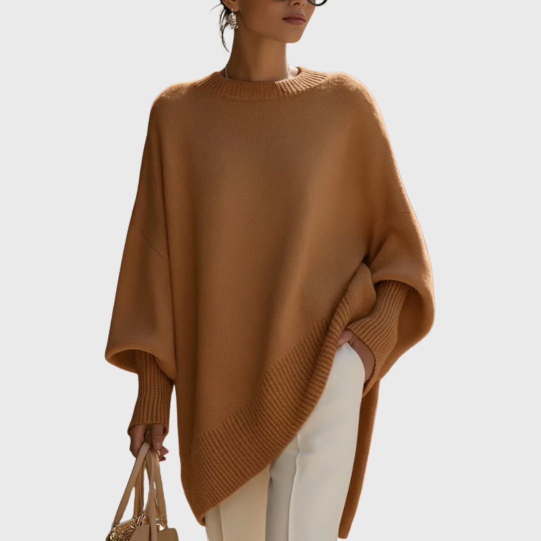 Dame iført ensfarvet oversize ponchobluse med rund hals og lange ribærmer