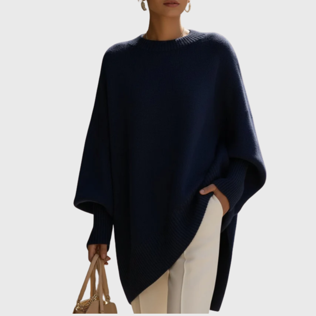 Dame iført ensfarvet oversize ponchobluse med rund hals og lange ribærmer
