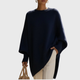 Dame iført ensfarvet oversize ponchobluse med rund hals og lange ribærmer