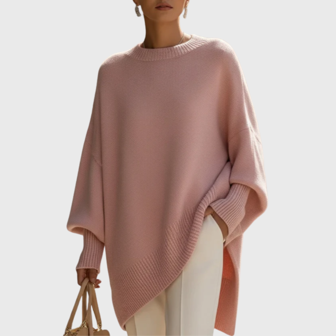 Dame iført ensfarvet oversize ponchobluse med rund hals og lange ribærmer