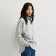 Dame iført ensfarvet sweatshirt med rund hals, lange ærmer og ribkanter
