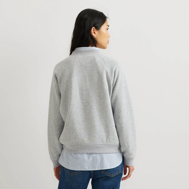 Dame iført ensfarvet sweatshirt med rund hals, lange ærmer og ribkanter
