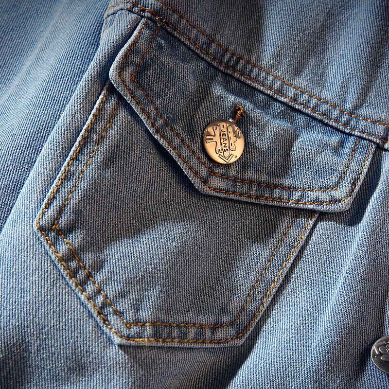 Lyseblå denimjakke til herre med stående krave, brystlommer og knaplukning