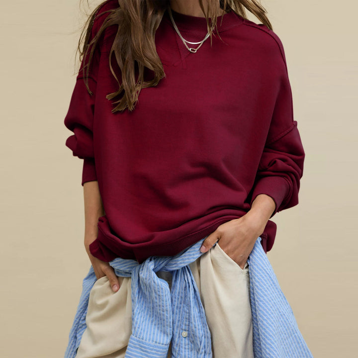 Dame iført ensfarvet sweatshirt med rund hals og lange ærmer