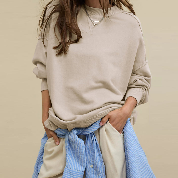 Dame iført ensfarvet sweatshirt med rund hals og lange ærmer