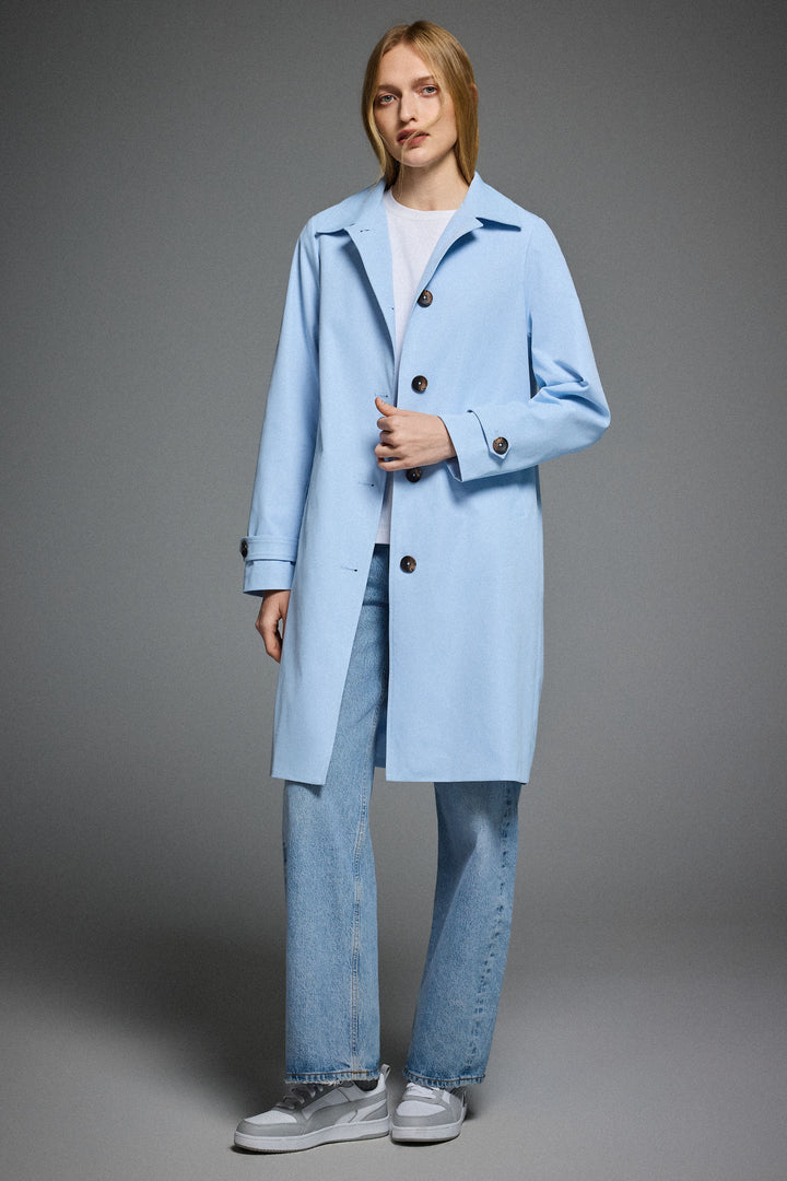 Dame i enradet trenchcoat med klassisk krave, knaplukning og lange ærmer