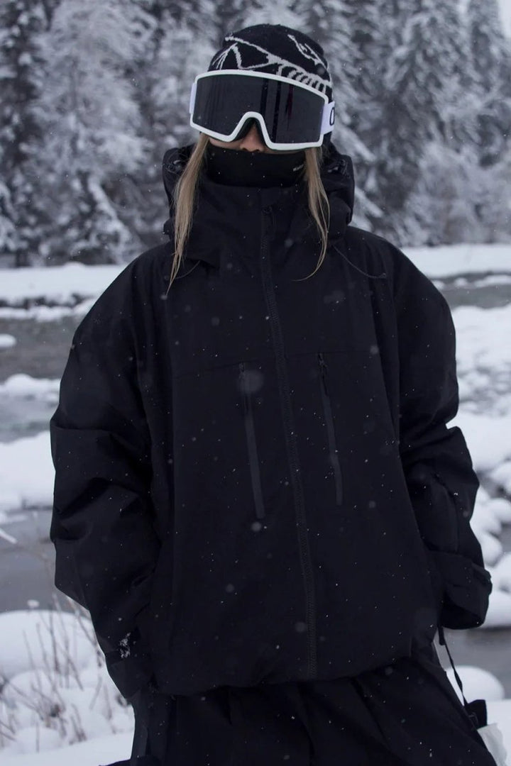 Unisex skijakke med hætte, lynlås og brystlommer i sneklædt vintermiljø