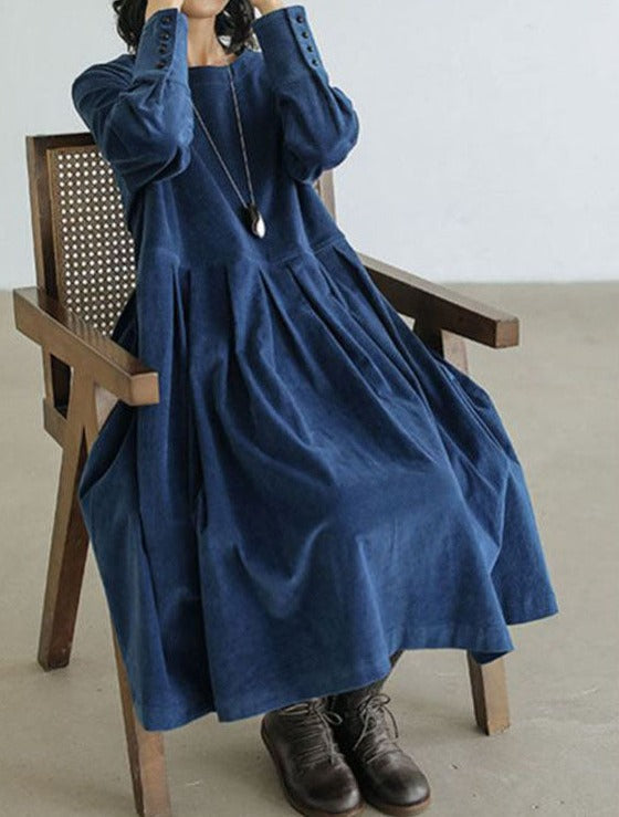 Lang ensfarvet damekjole med rund hals, lange ærmer og vid nederdel