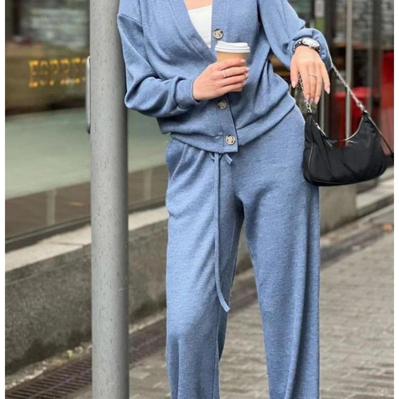 Dame i ensfarvet strikkesæt med cardigan med knapper og lange bukser