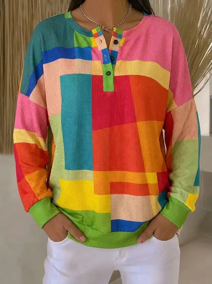 Dame i flerfarvet sweatshirt med geometrisk mønster og knapper