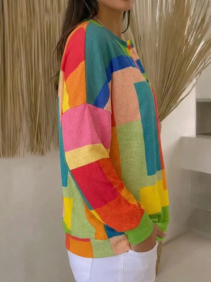 Dame i flerfarvet sweatshirt med geometrisk mønster og knapper