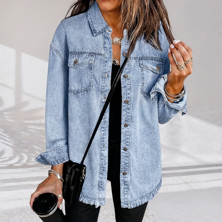 Dame i oversized denimjakke med brystlommer og frynset kant