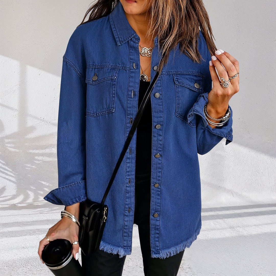 Dame i oversized denimjakke med brystlommer og frynset kant
