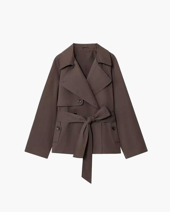 Dame i kort trenchcoat med reverskrave, lange ærmer og bindebælte