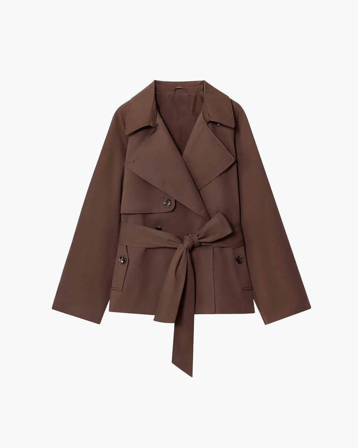 Dame i kort trenchcoat med reverskrave, lange ærmer og bindebælte